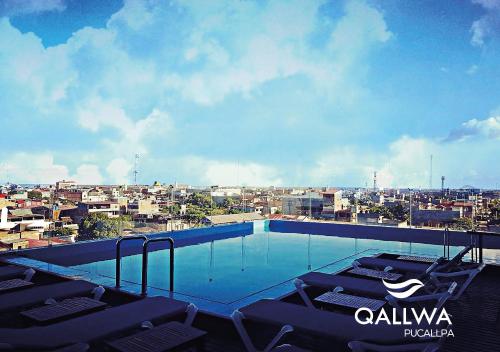 a swimming pool with lounge chairs and a city at Qallwa Pucallpa in Pucallpa