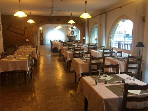 un comedor con mesas y sillas en un restaurante en Le Guilazur en Château-Ville-Vieille