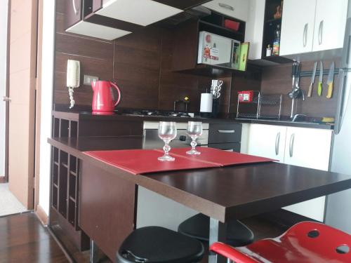 - une cuisine avec une table et 2 verres à vin dans l'établissement Teatinos 690, à Santiago
