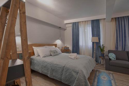 a bedroom with a bed and a chair and a couch at Sali Boutique hotel in Alexandroupoli