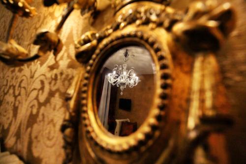 a mirror hanging on a wall with a chandelier at Ca' Pagan in Venice