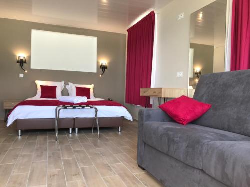 a bedroom with a bed and a couch at Diamant les bains - Résidence Hôtelière in Le Diamant