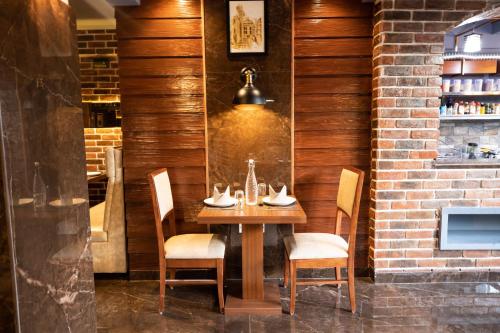 a dining room with a wooden table and chairs at Hotel Paramos Inn in Bengaluru