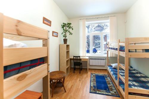 a room with two bunk beds and a desk at Hostel Hunter House in Tomsk