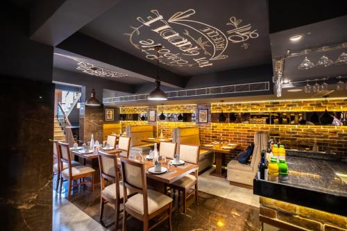 a restaurant with tables and chairs and a bar at Hotel Paramos Inn in Bengaluru