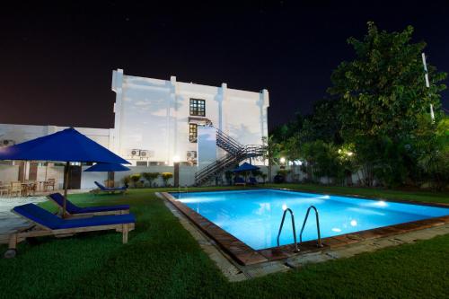 a swimming pool in front of a building at night at Hotel Timor in Dili