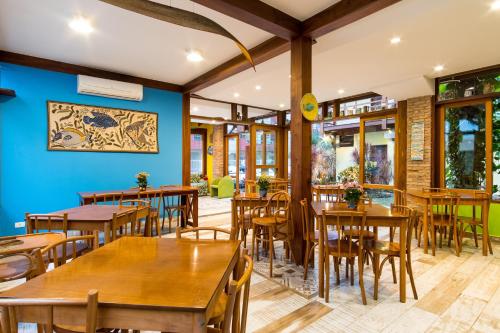 een restaurant met houten tafels en stoelen en blauwe muren bij Pousada Peixes do Mar in Ubatuba