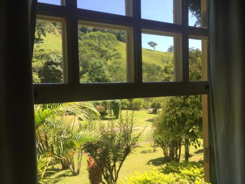 a view from a window of a garden at Pousada Primavera in São Luiz do Paraitinga