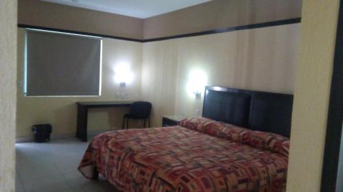 a hotel room with a bed and a desk at Jalyd Inn in Irapuato