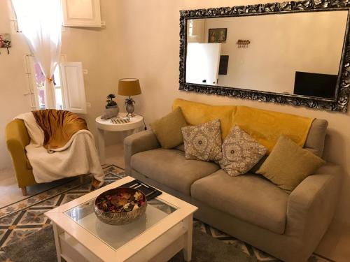 a living room with a couch and a mirror at Amelie in Rabat