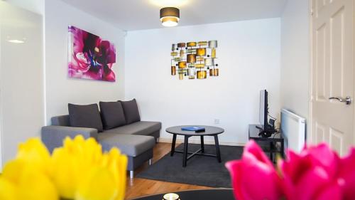 ein Wohnzimmer mit einem Sofa und einem Tisch in der Unterkunft UR City Pad - Regent Wharf in Walsall