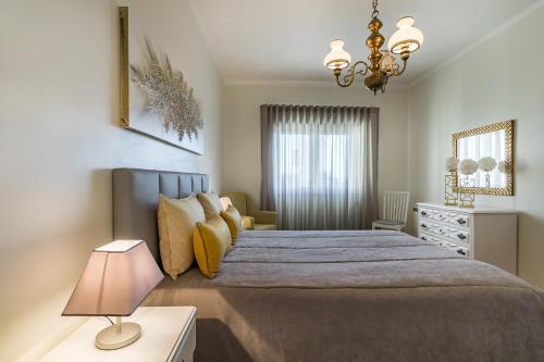 a bedroom with a large bed and a lamp at Sea & Relax Villa Nazaré in Nazaré