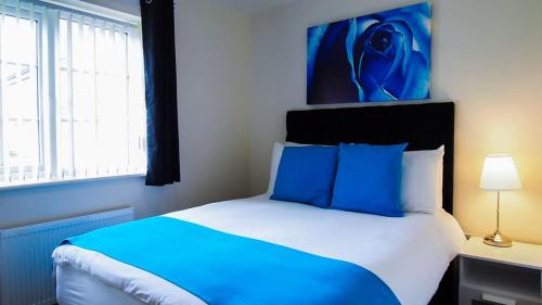 - une chambre bleue et blanche avec un lit et une fenêtre dans l'établissement UR City Pad - Regent Wharf, à Walsall