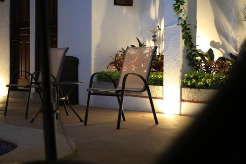 two chairs and a table in a room with plants at Hotel Santa Paula in Taxco de Alarcón