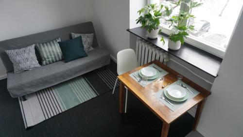 una pequeña sala de estar con mesa y sofá en Lovely Bubbly Apartment en Cracovia