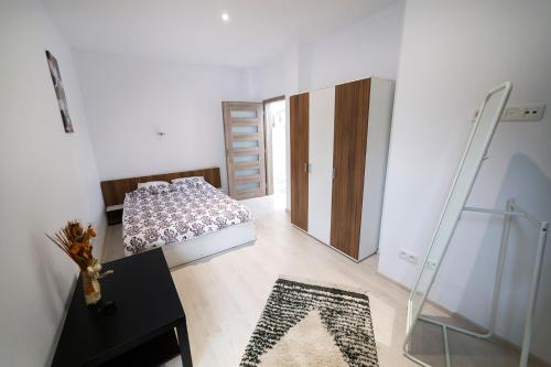 a bedroom with a bed and a table and a mirror at Central apartment- Shumi's in Cluj-Napoca