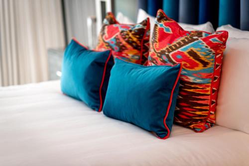 a group of pillows sitting on top of a bed at The Sagamore Hotel South Beach in Miami Beach