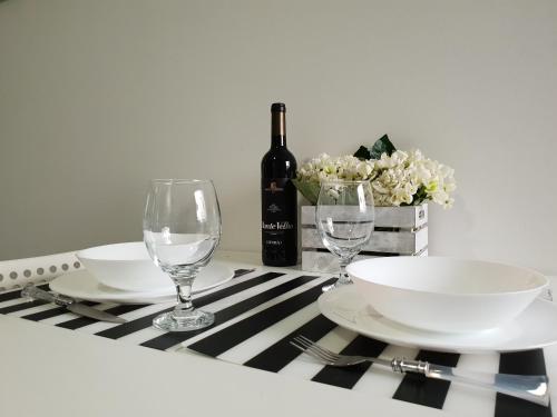 - une table avec des assiettes, des verres et une bouteille de vin dans l'établissement Charming Pedra, à Braga