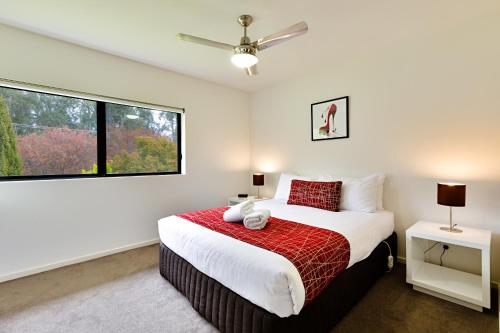 een slaapkamer met een groot bed en een raam bij Apex Park Holiday Apartments in Wangaratta