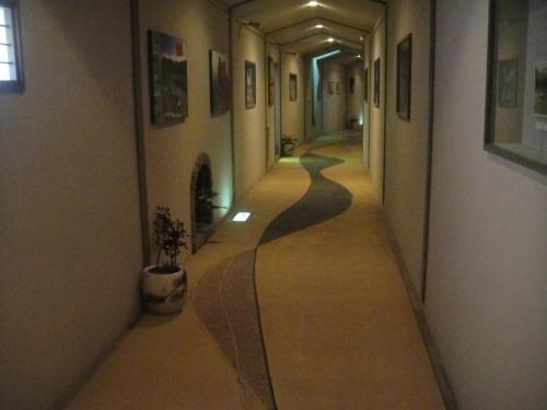an empty hallway in a building with paintings on the walls at Kurhaus Ishibashi Ryokan in Shimoda