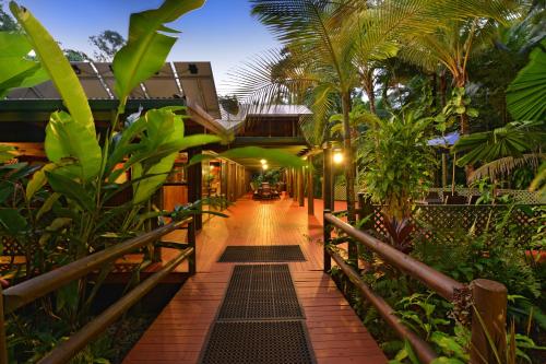 a walkway through a resort with trees and plants at Wait-a-While Eco Retreat in Cow Bay