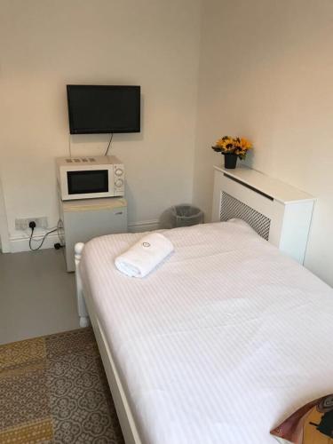 a bedroom with a bed and a tv on the wall at Circle Guest House Bed Only in Southampton
