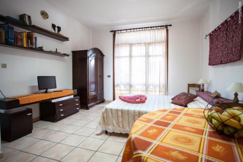 a bedroom with a bed and a desk and a television at Residenza Su Prelau in Gonnesa