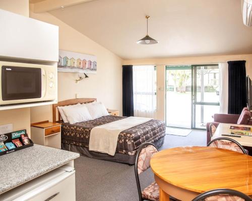 a small hotel room with a bed and a table at Goldmine Motel in Waihi