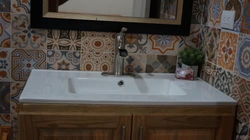 a bathroom sink with a faucet and a mirror at Pirates Rock 101 in Utila