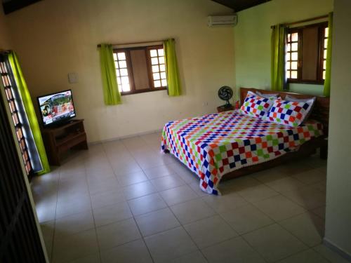 a bedroom with a bed and a tv in it at Casa Melo e Azevedo in São Miguel dos Milagres