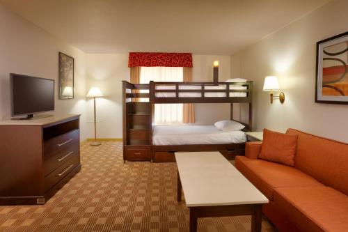 a hotel room with a bunk bed and a couch at Cortona Inn and Suites Anaheim Resort in Anaheim