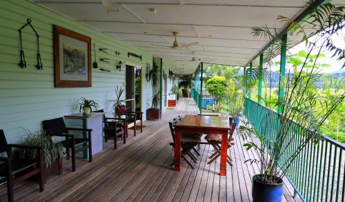 a porch with a table and chairs on a deck at Daintree Riverview Lodges in Daintree