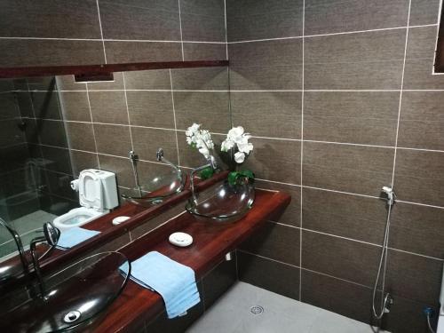 a bathroom with a sink and a vase of flowers at Casa Melo e Azevedo in São Miguel dos Milagres