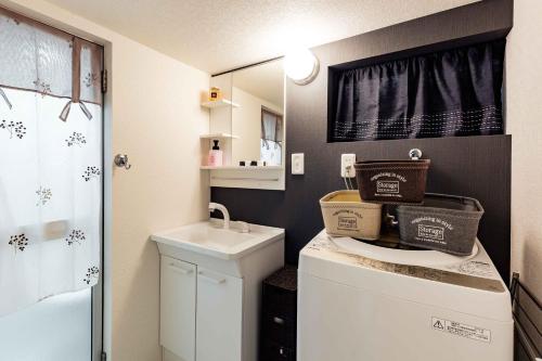 mała łazienka z pralką i suszarką w obiekcie Prestige Suites Osaka Abiko w Osace