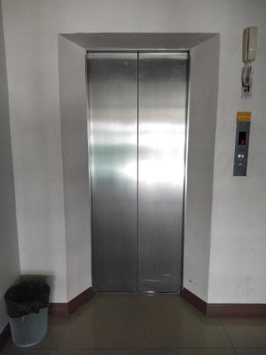 a metal elevator in a building with a trash can at Amatara Hotel in Pi Mai