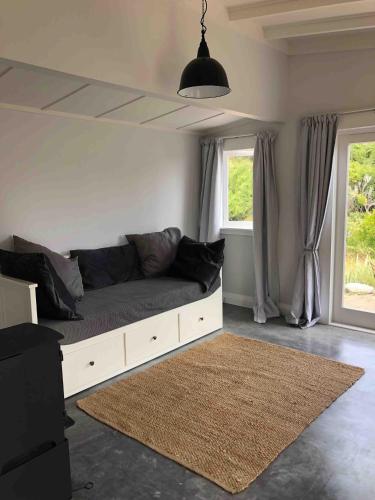a living room with a couch and two windows at The Pear Orchard Lodge in Richmond