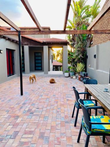 a patio with two dogs and two tables and chairs at Stay at 11 on Gull in Cape Town