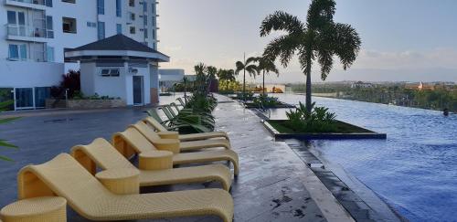 eine Sitzreihe neben einem Pool auf einem Gebäude in der Unterkunft Apartment Sea View at Mactan Newtown in Mactan