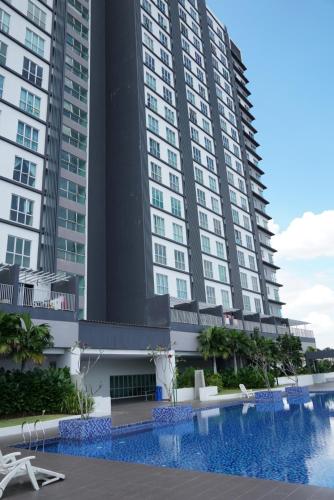 ein großes Gebäude mit einem Pool davor in der Unterkunft 2 Carpark GEP 5 Star Hotel Bed & Sofa Studio in Seri Kembangan