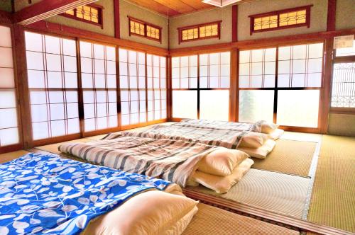 um quarto com duas camas num quarto com janelas em Matakitai em Ichinoseki