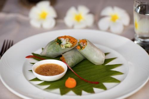 a white plate with food on a table at Farmhouse Resort & Spa in Kampong Chhnang