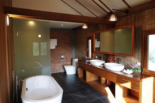 a bathroom with two sinks and two toilets at Farmhouse Resort & Spa in Kampong Chhnang