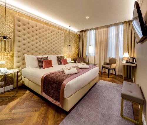 a bedroom with a large bed with a large headboard at BW Premier Collection CHC Continental in Venice