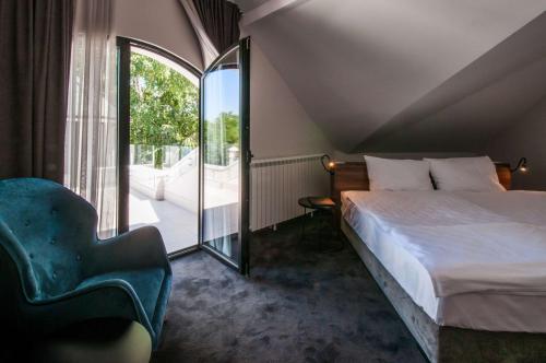 a bedroom with a bed, chair and a window at Best Western Premier Natalija Residence in Belgrade