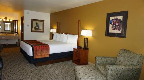 a hotel room with a bed and a chair at Best Western Grande River Inn & Suites in Grand Junction