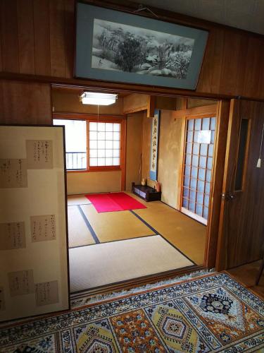 a room with a door open to a room with a rug at Ikkenya Kitagata in Okayama