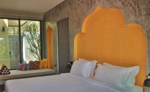 1 dormitorio con 1 cama con cabecero naranja en Mook Lamai Resort and Spa, en Ko Mook