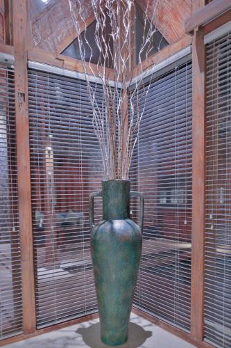 a green vase with branches in it in front of a window at Samsara Villas in Gili Air