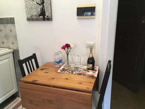 a table with a bottle of wine and flowers on it at LeopardElla in Rome