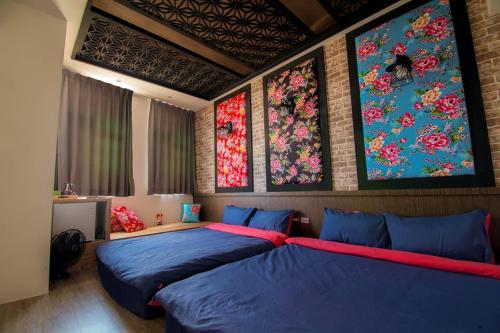 two beds in a room with paintings on the wall at Liuqiu Antique Tea House in Xiaoliuqiu